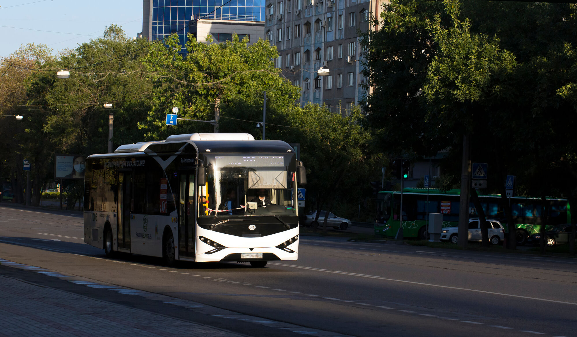 Bus driving on a street at sunset