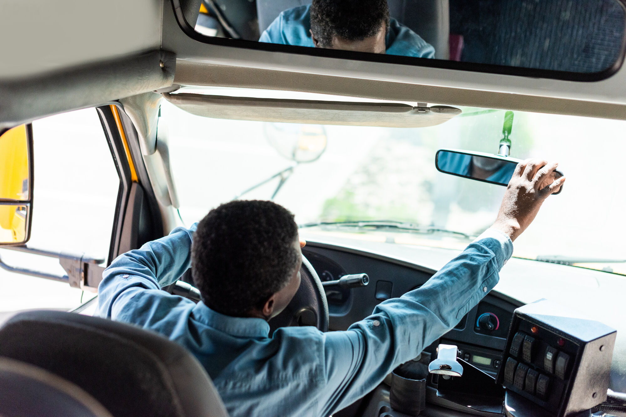 Bus driver checking the rear-view mirror