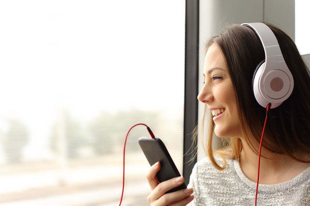 Teen passenger listening to the music traveling in a train