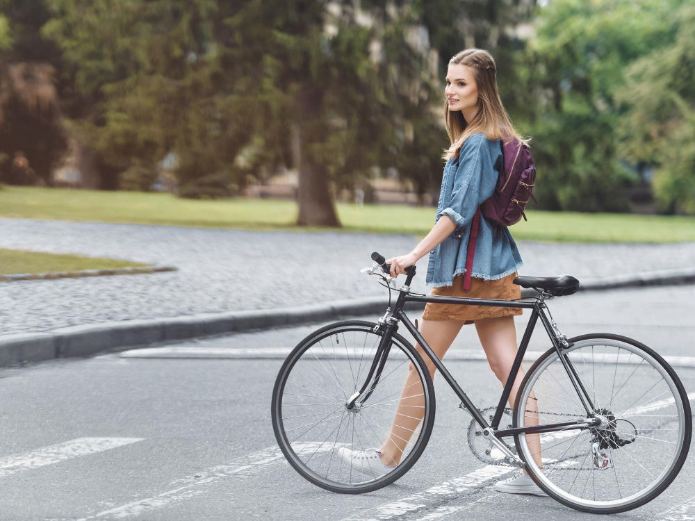 Un aragazza che attraversa la strada con una e-bike - un componente fondamentale del MaaS