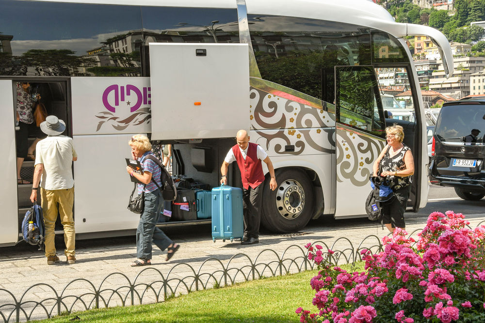 Passeggeri che caricano bagagli sull'autobus